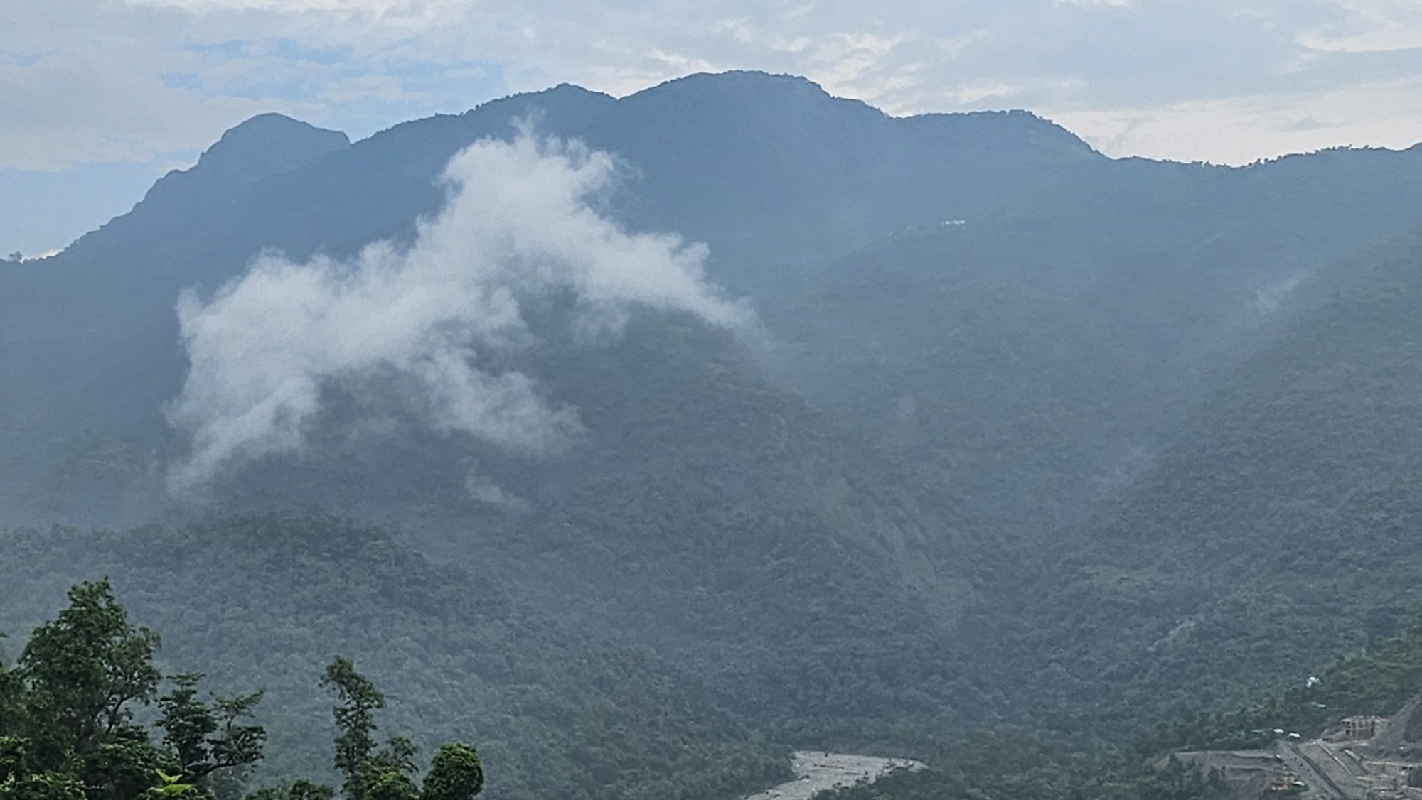 Cloud rising off a forested ridge above the valley at Dolsi Village, Tehsil Dhanaulti